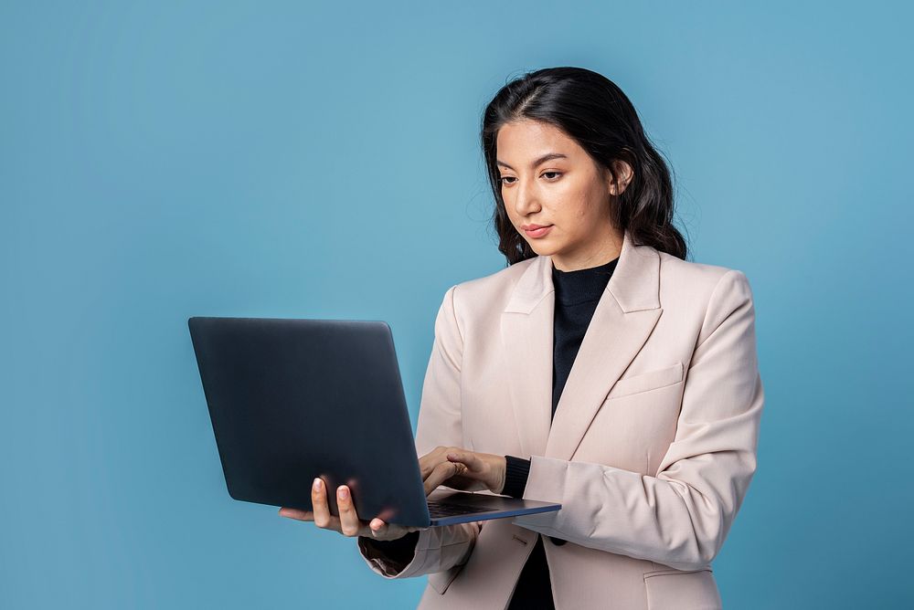 Businesswoman using a laptop on blue background
