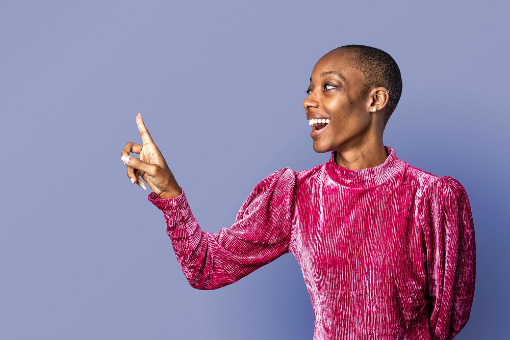 Black woman in a pink dress pointing forward 