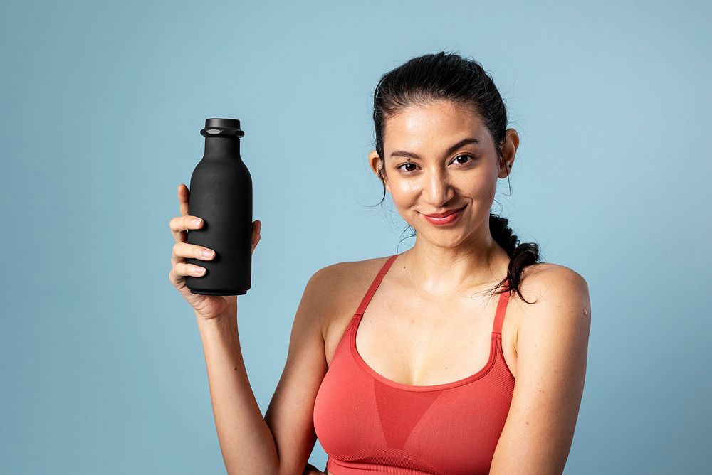 Sporty woman holding a black bottle