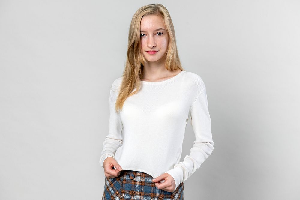 Young blonde girl wearing white sweater