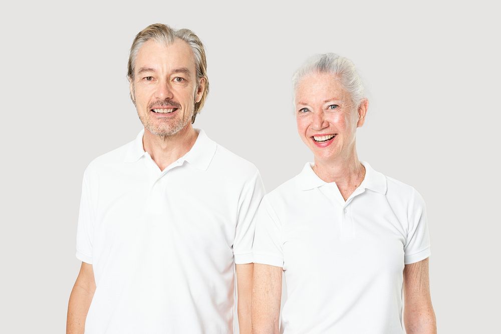 Happy senior couple in white polo shirts with design space studio portrait