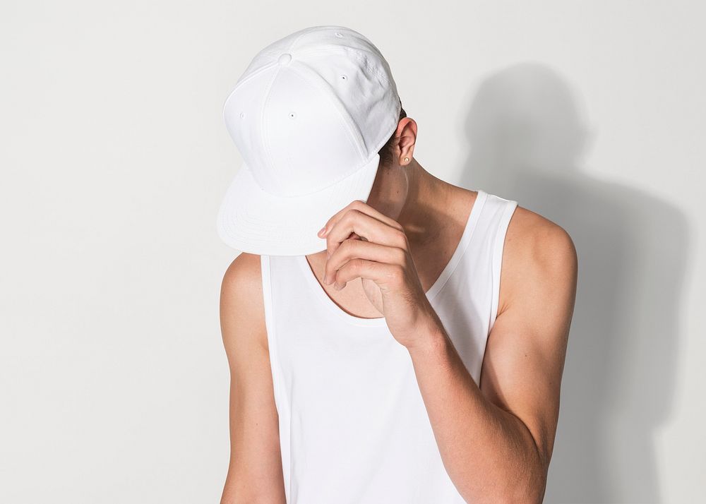 Teenage boy in white snapback cap and tank top street fashion shoot