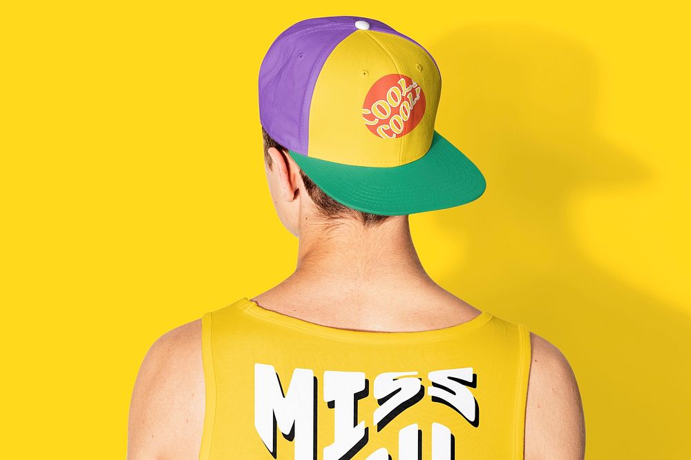 Teenage boy in colorful snapback cap and tank top street fashion shoot rear view