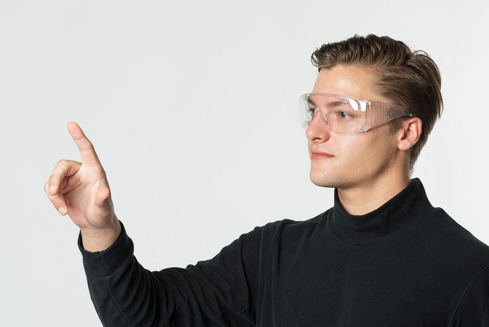 Man wearing safety goggles pointing out his index finger