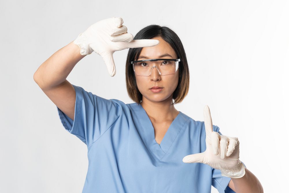 Medical worker in medical uniform doing a zoom gesture on invisible screen 