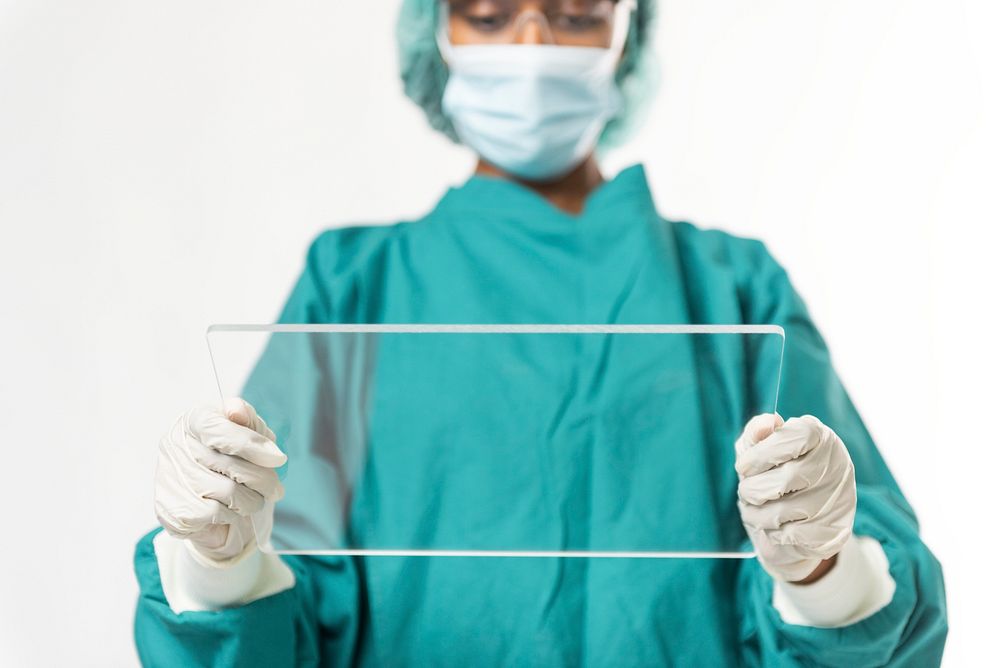 Doctor holding futuristic transparent tablet screen with design space
