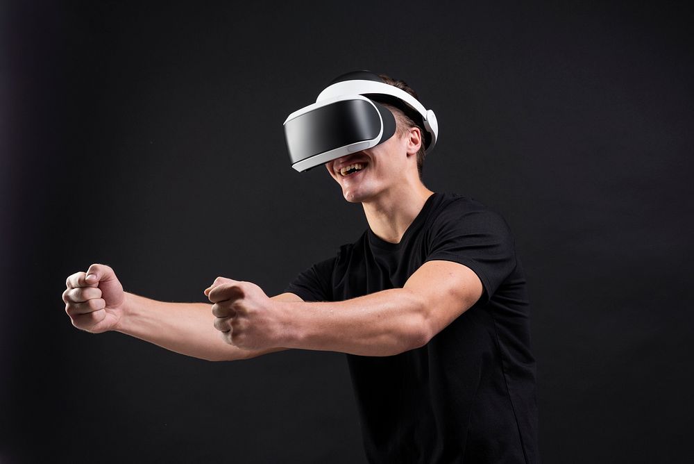 Man playing games with VR goggles black background
