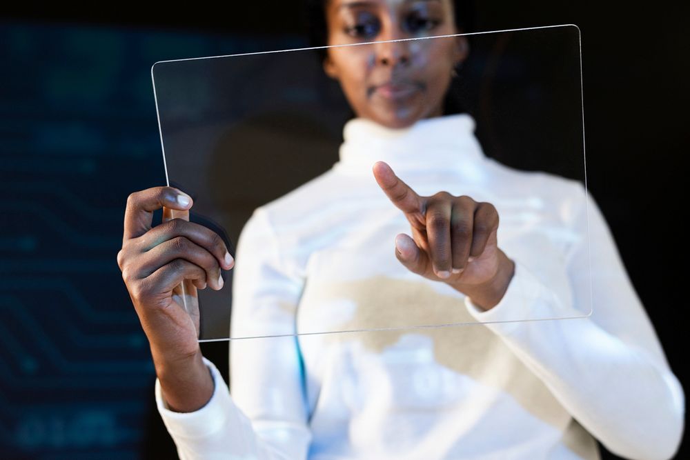 African American woman using transparent tablet futuristic technology