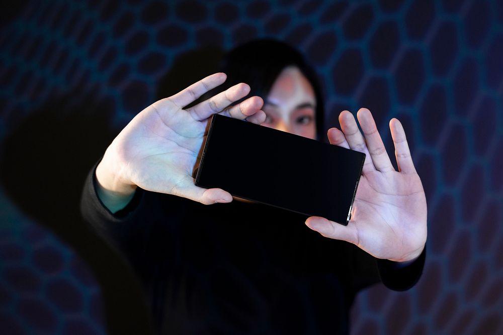 Woman showing smartphone screen mockup psd 