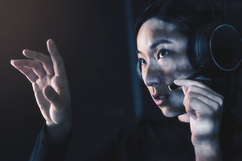 Female operator with headphones touching virtual screen
