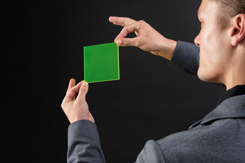 Businessman holding green hologram plate