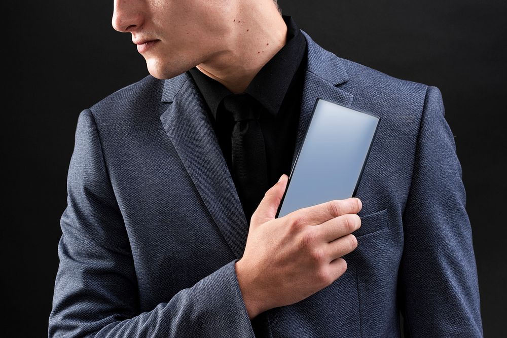 Businessman in suit showing his smartphone device 