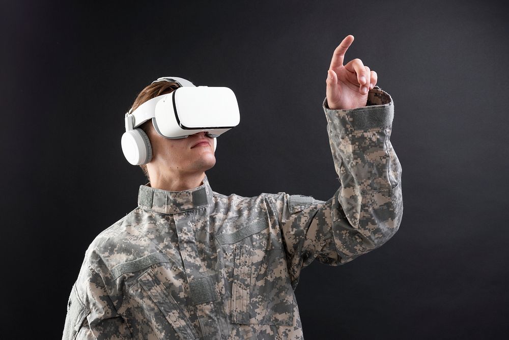 Military in VR headset touching virtual screen 