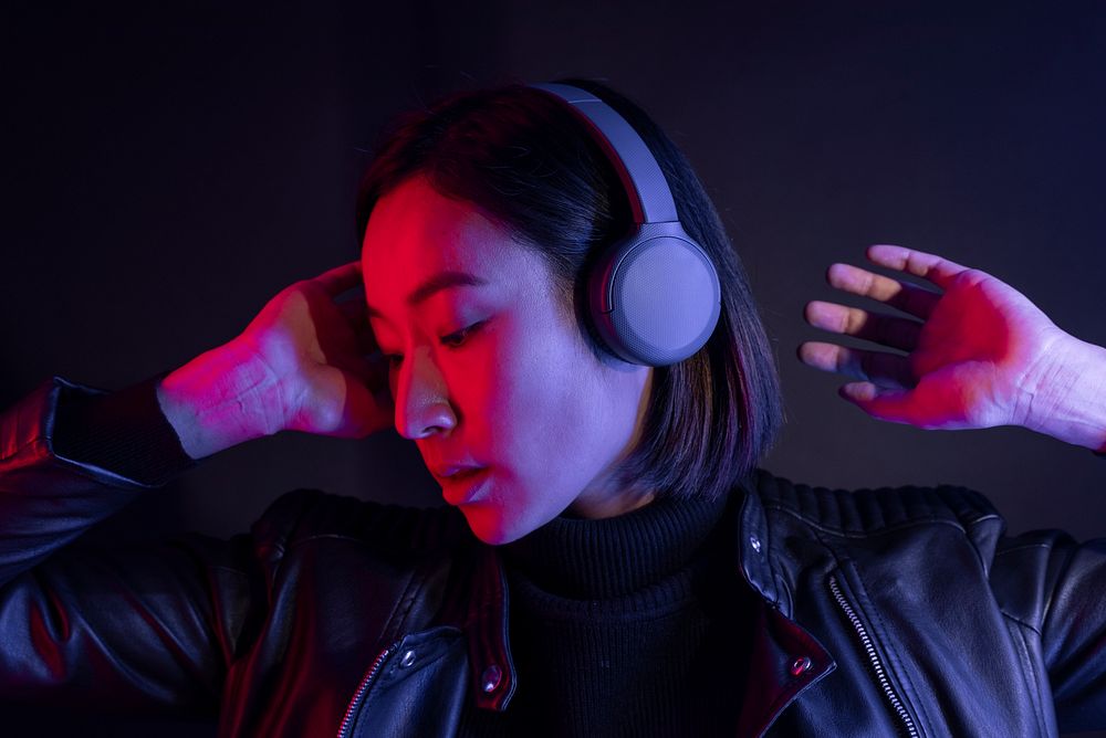 Asian woman listening to music with wireless headphones