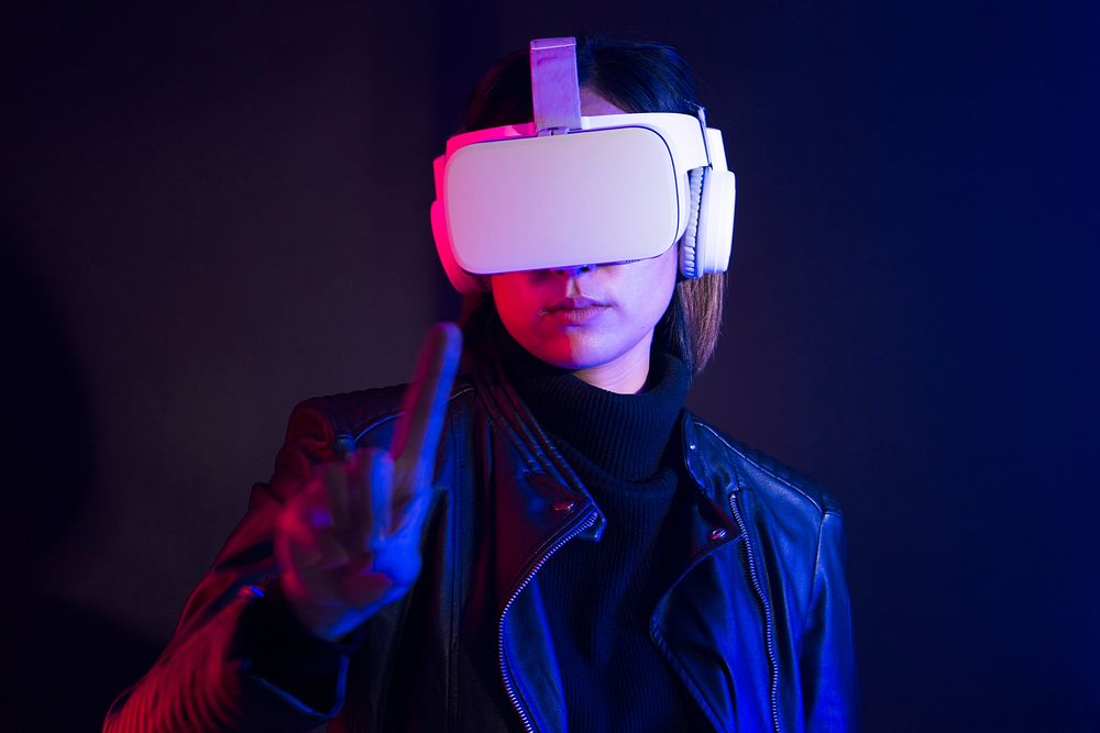 Woman playing games with VR goggles blue background
