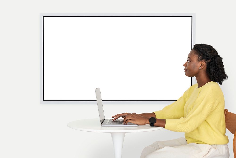 Blank projecting screen with college student working on a laptop