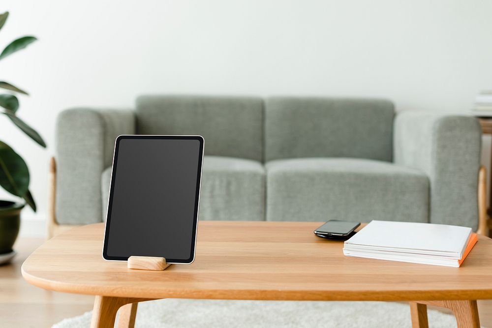 Digital tablet black screen mockup psd on a wooden table