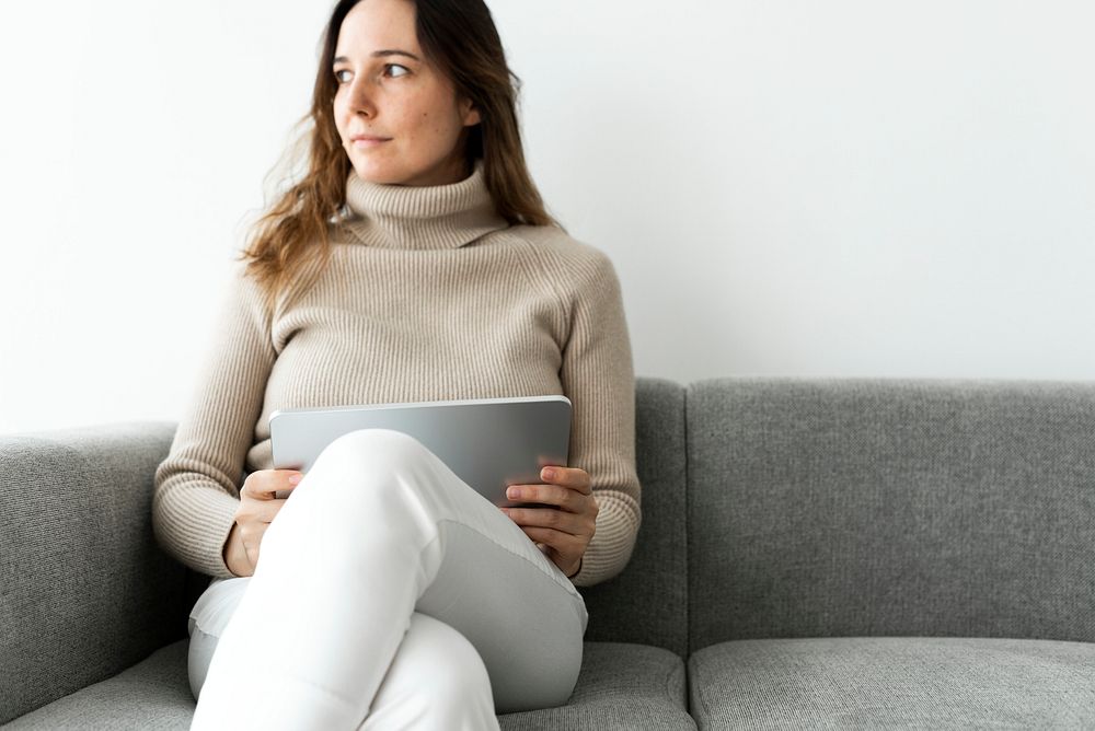 Woman using digital tablet on a couch