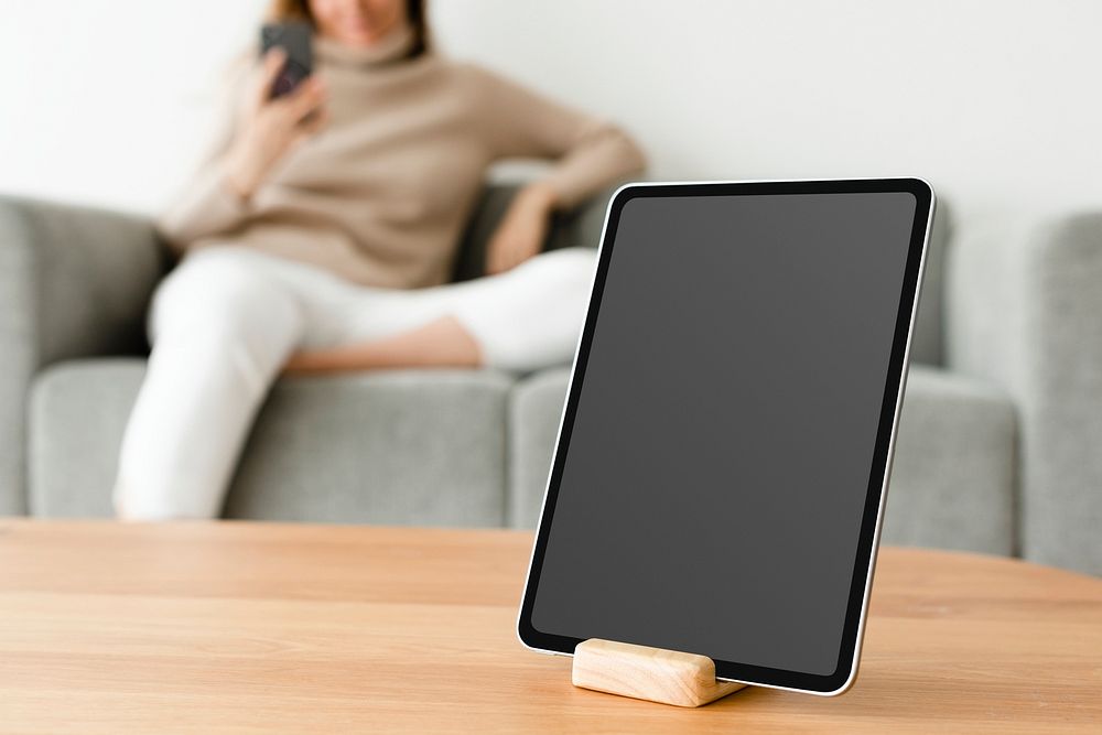 Digital tablet black screen mockup psd on a wooden table