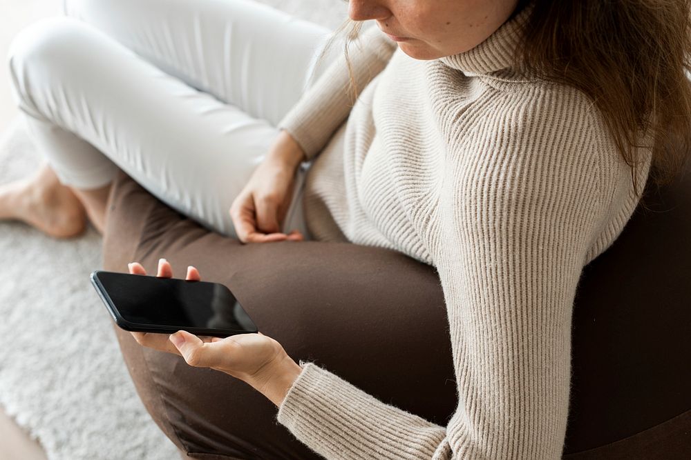 Woman using smartphone on a couch