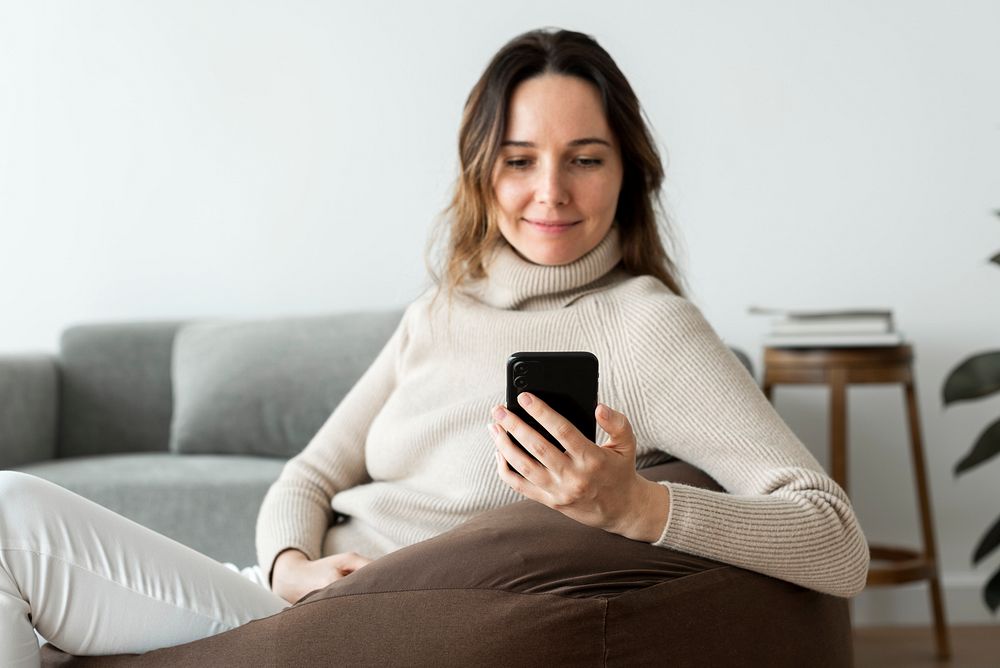 Woman using smartphone on a bean bag