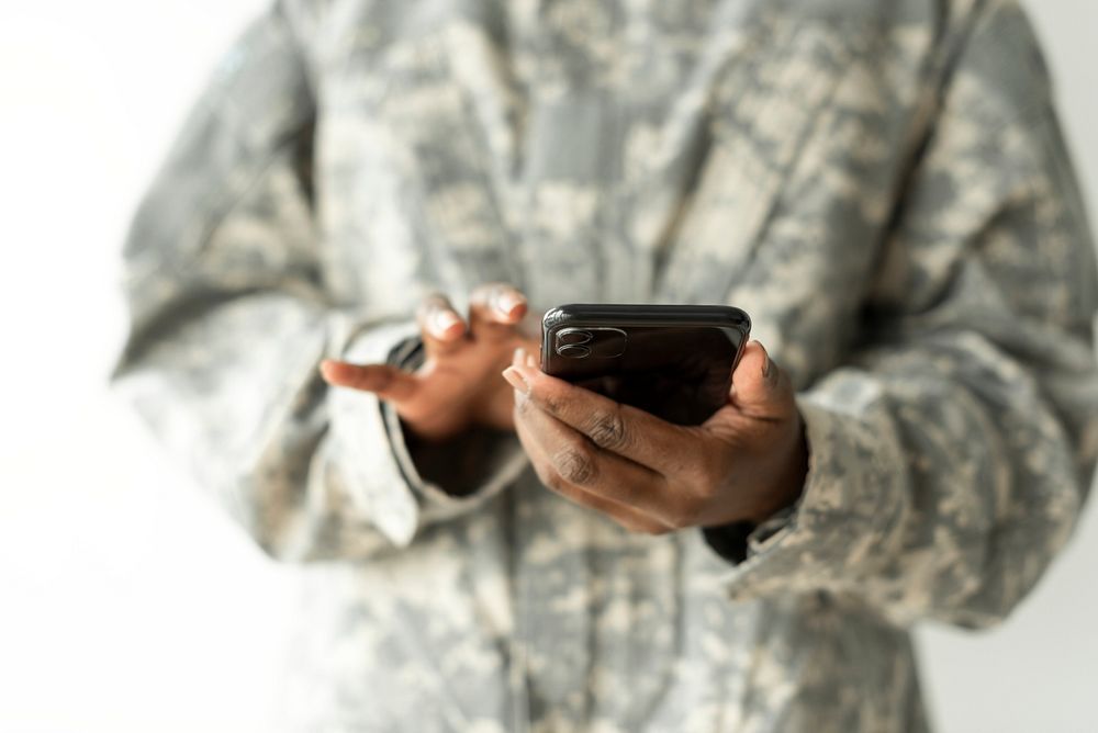 Female soldier using on a smartphone communication technology