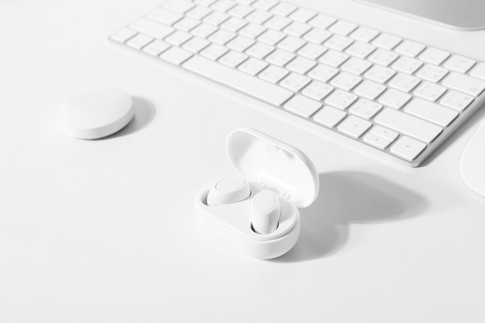 White wireless earbuds mockup psd with computer keyboard