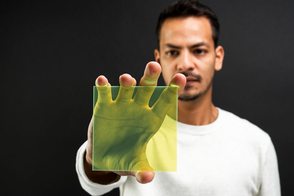 Man presenting yellow transparent plate futuristic technology