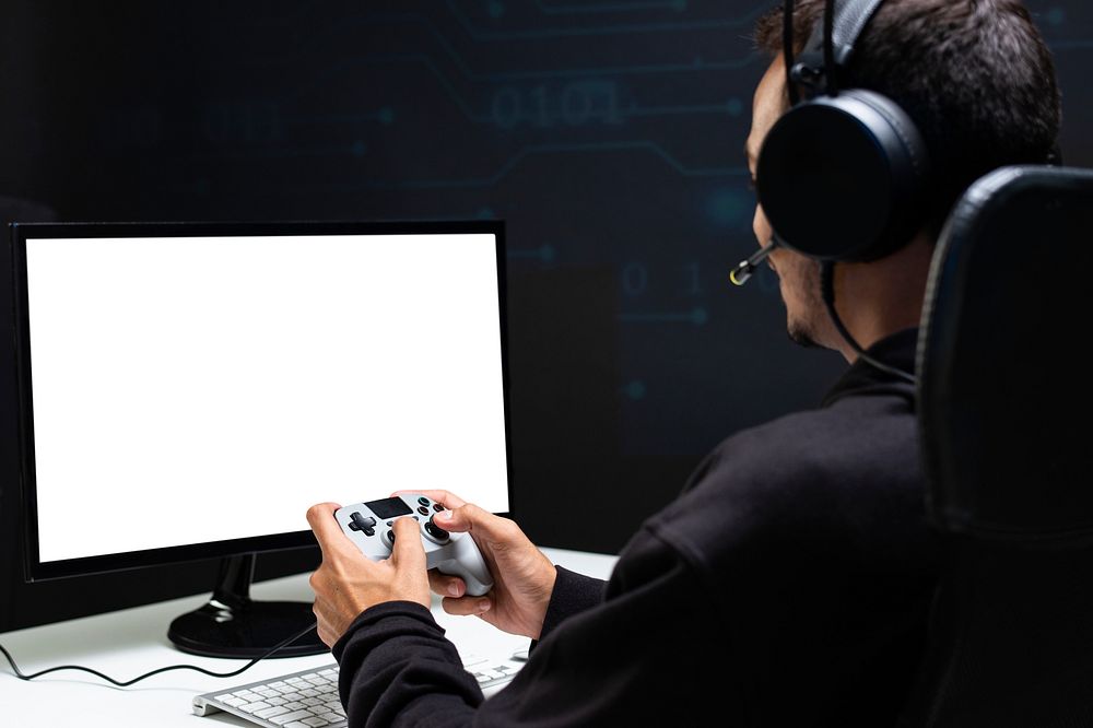 Man playing a game with blank screen computer holding a gaming controller