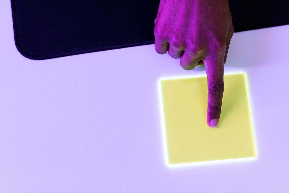 Index finger pressing on yellow transparent plate advanced technology