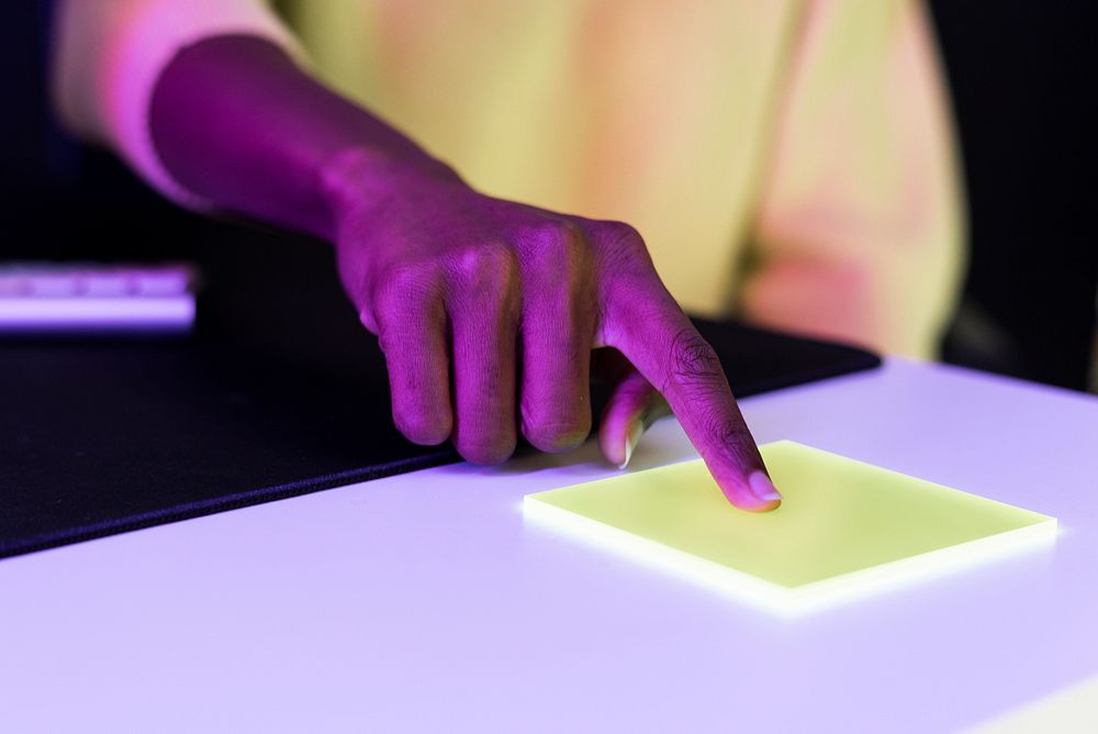 Index finger pressing on yellow transparent plate smart technology