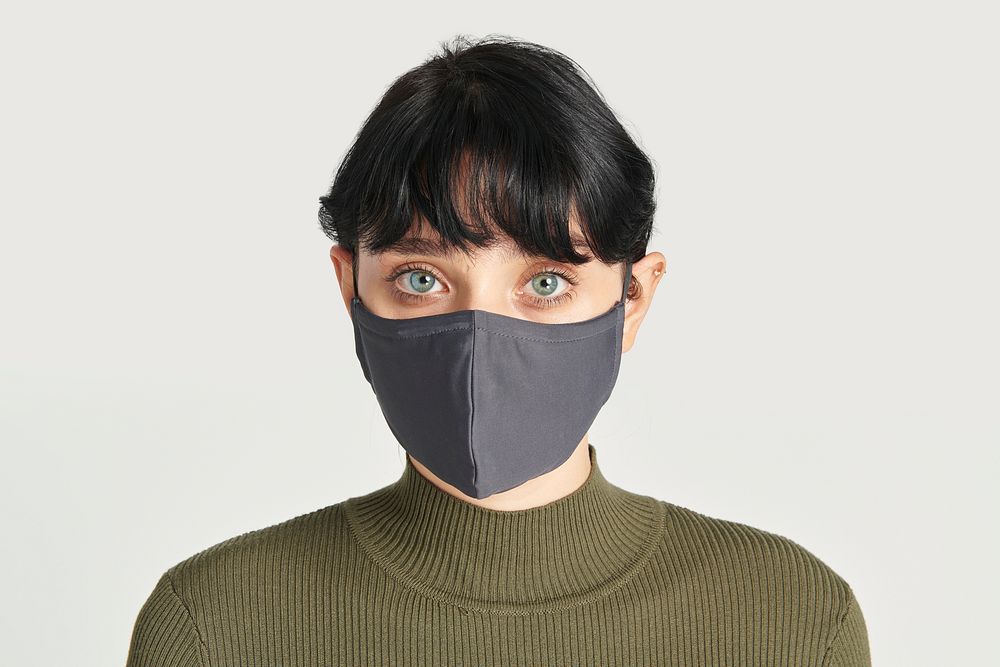 Face mask on a women in a green turtleneck top