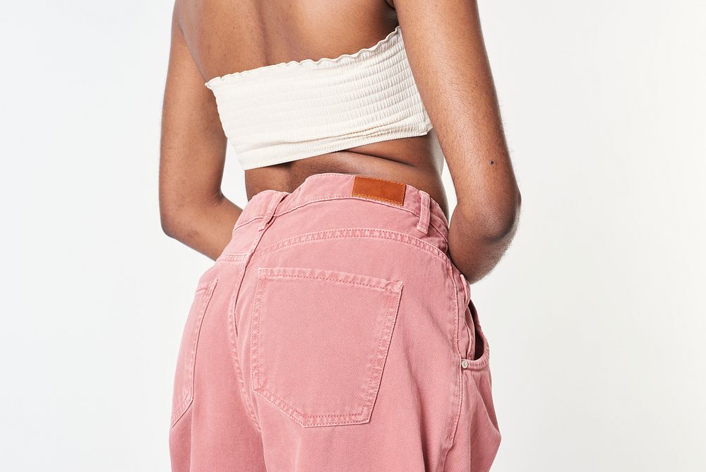 Black woman in pink jeans and a white bandeau top
