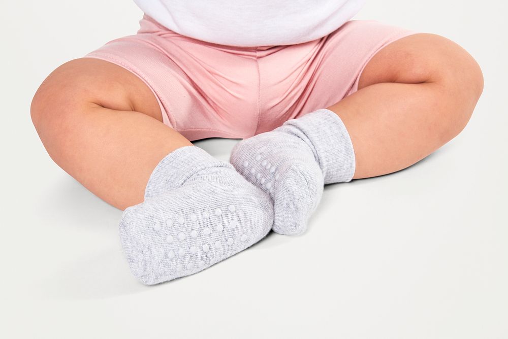 Baby wearing sock sitting on the floor