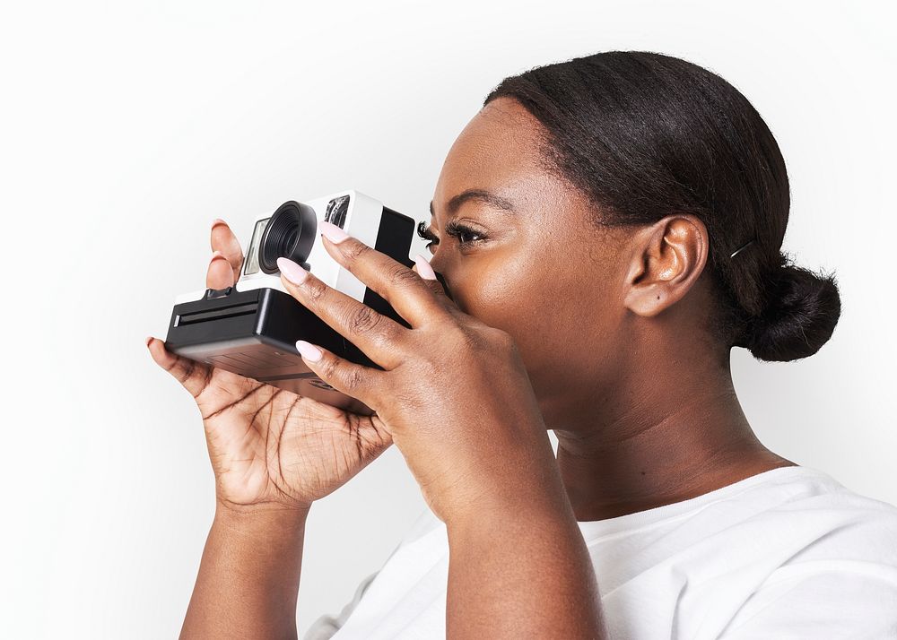 Psd woman holding a polaroid camera facing side mockup