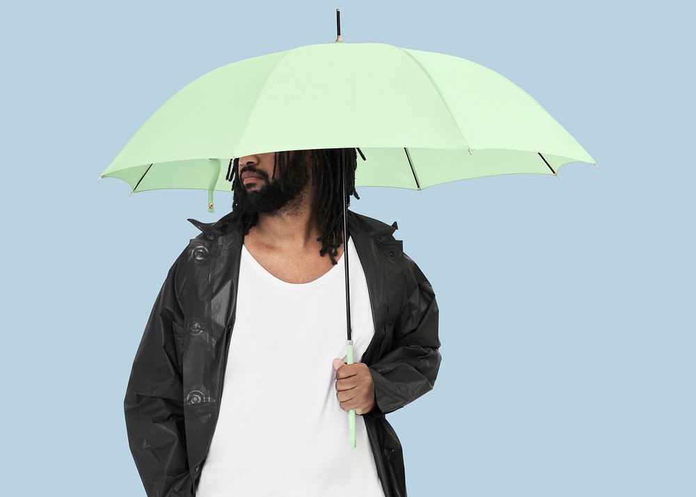 Man holding green umbrella studio shot