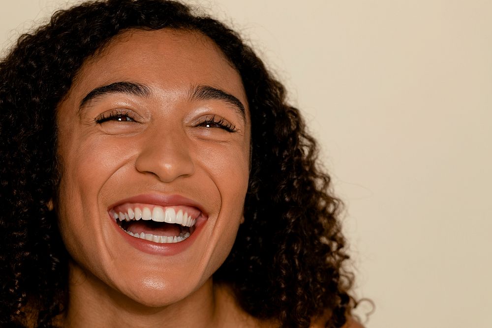 Happy woman smiling, beige background