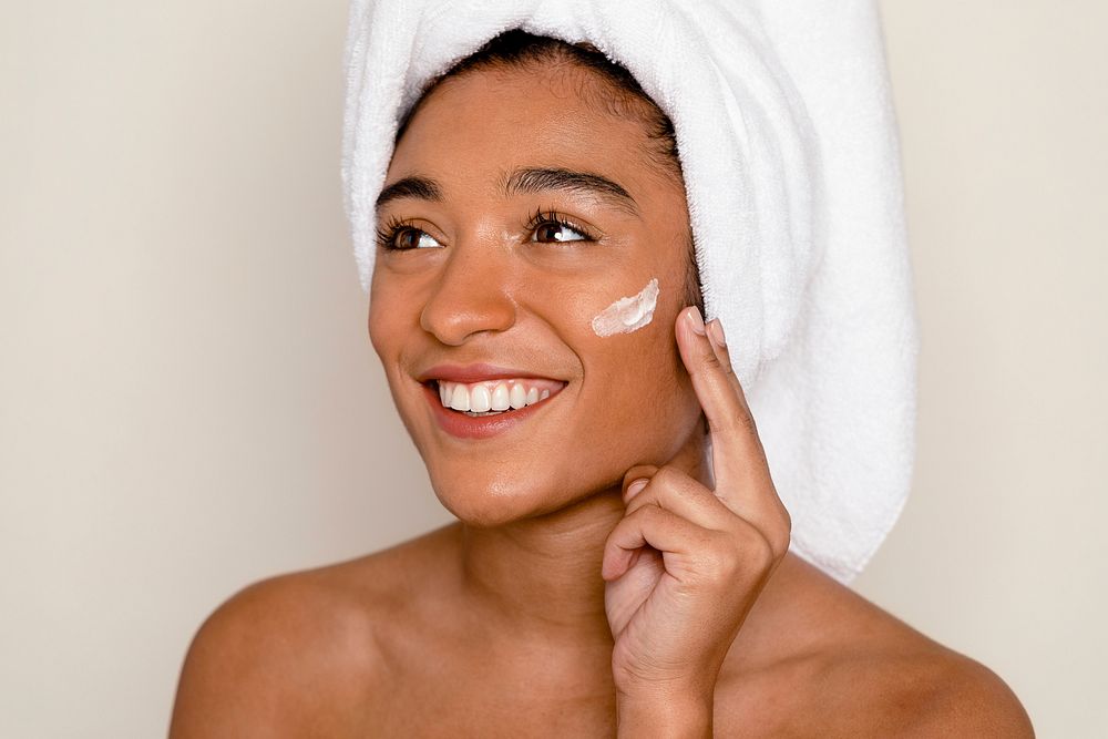 Smiling woman applying face cream