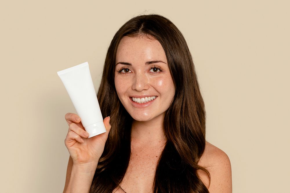 Woman holding face moisturizer tube
