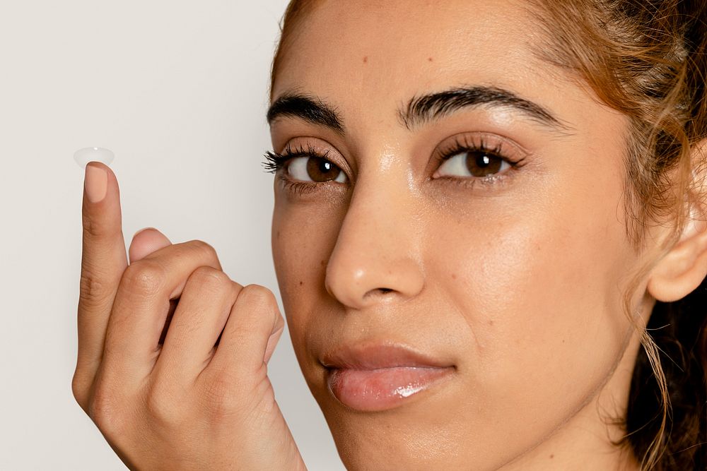 Woman applying lens on eye