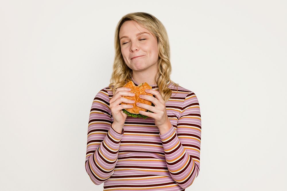 Happy woman eating a hamburger for lunch