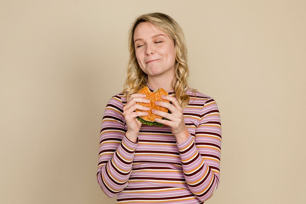 Happy woman eating a hamburger for lunch