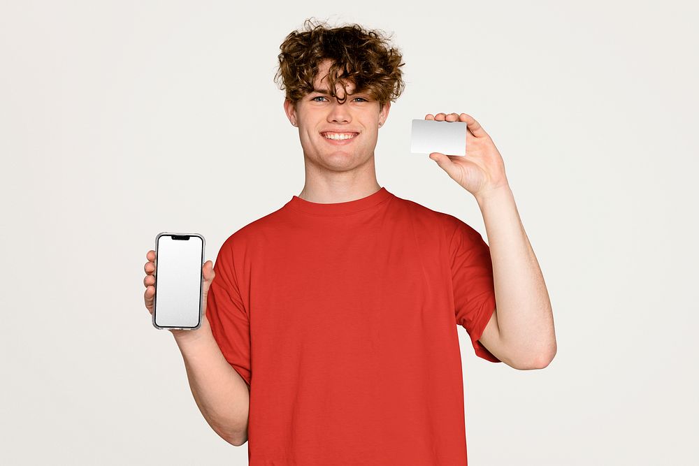 Young man holding phone and blank credit card