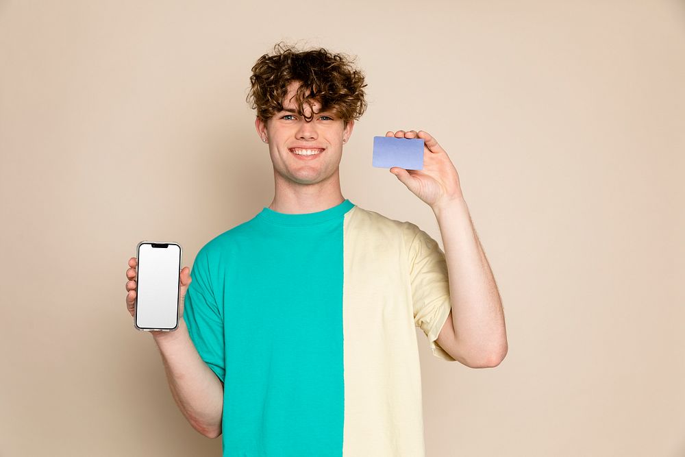 Young man holding phone and blank credit card