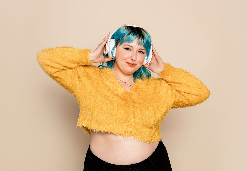 Curvy woman with cropped sweater and headphones