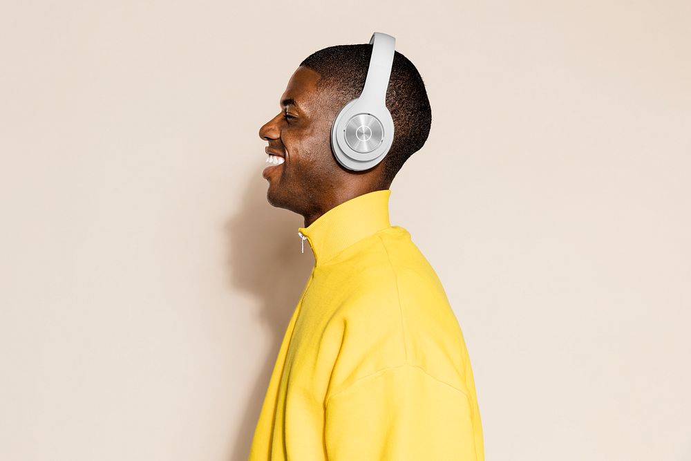 Man listening to music, beige background