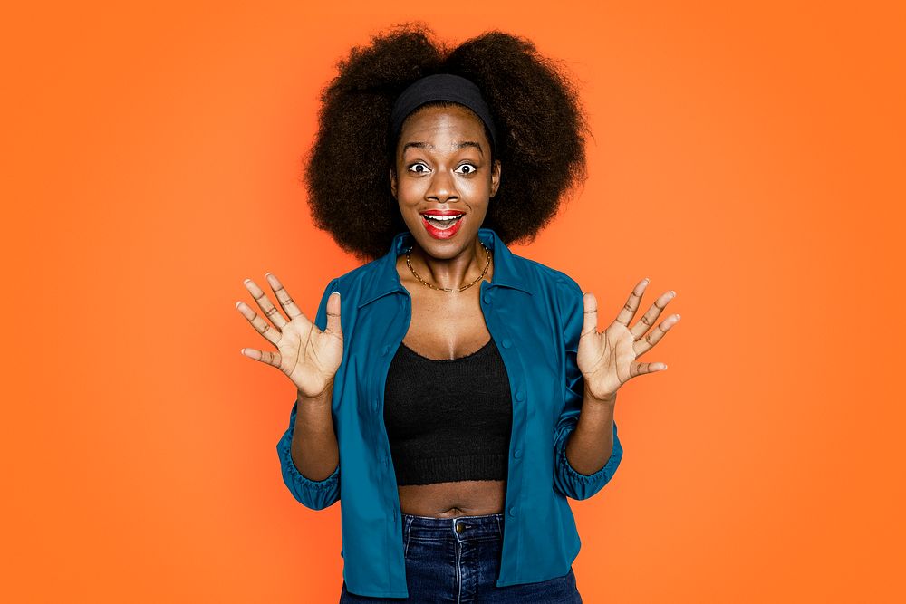 Surprised African American woman on orange background
