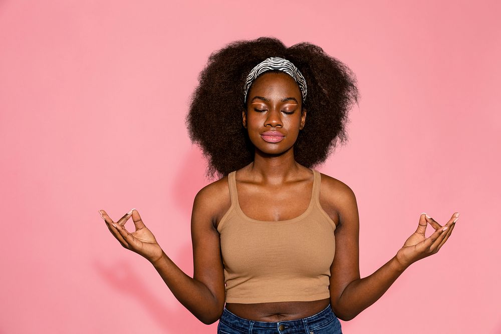 Meditating woman on pink background