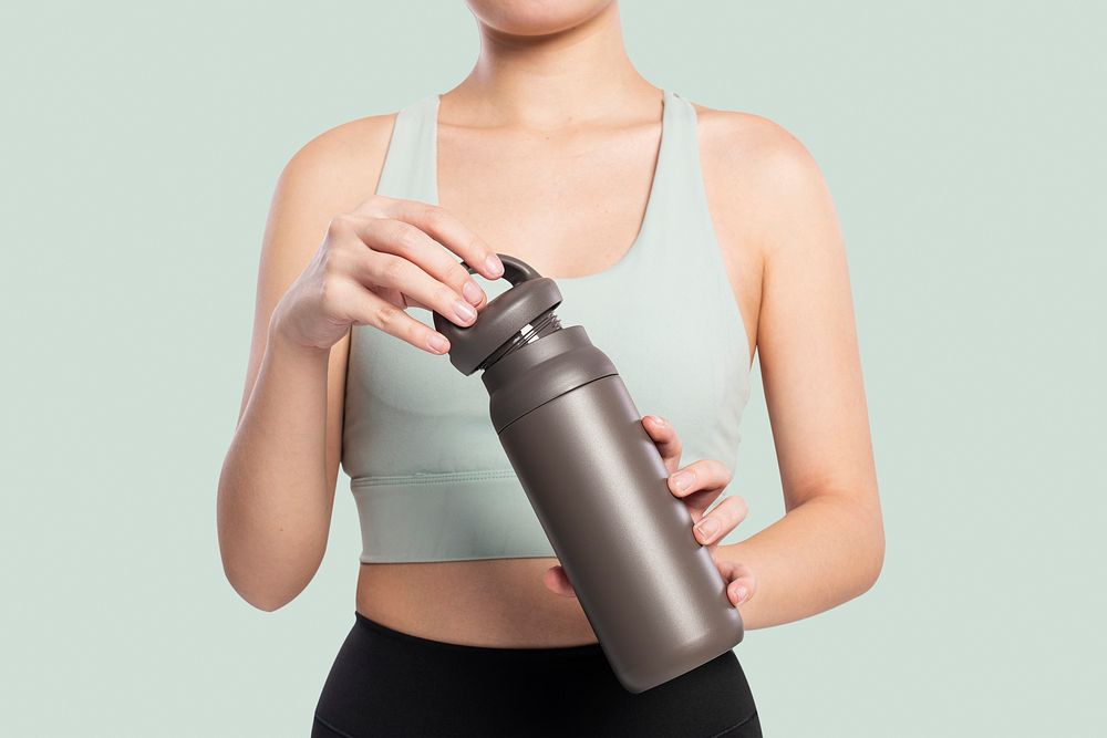 Active woman mockup psd holding a stainless steel water bottle
