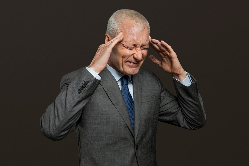 Stressed senior businessman touching his head